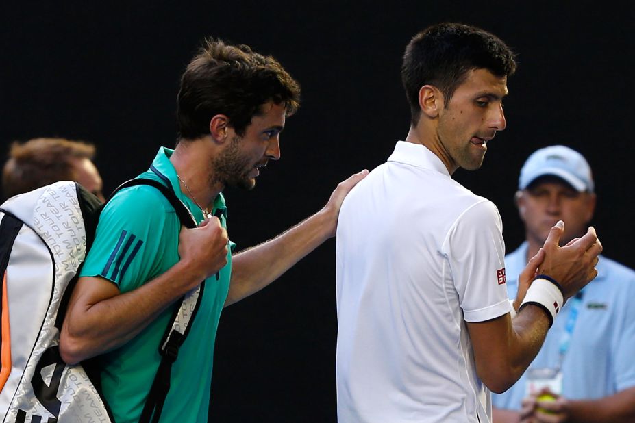 Gilles Simon of France embraces Novak Djokovic after their five-set marathon in Melbourne, eventually won by the top-seeded Serbian.  