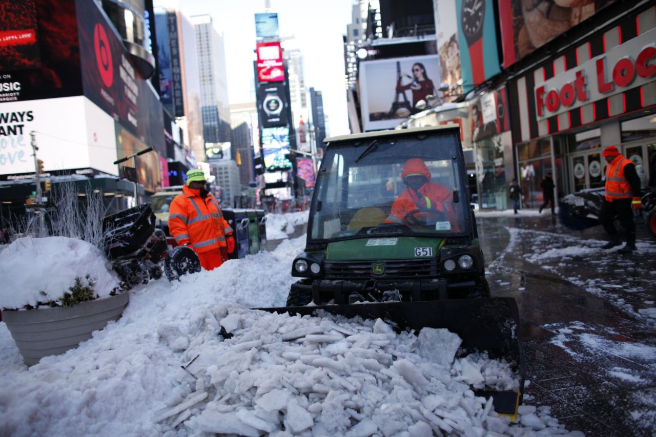 Workers clean a snow-covered street in New York's Times Square on January 24. 