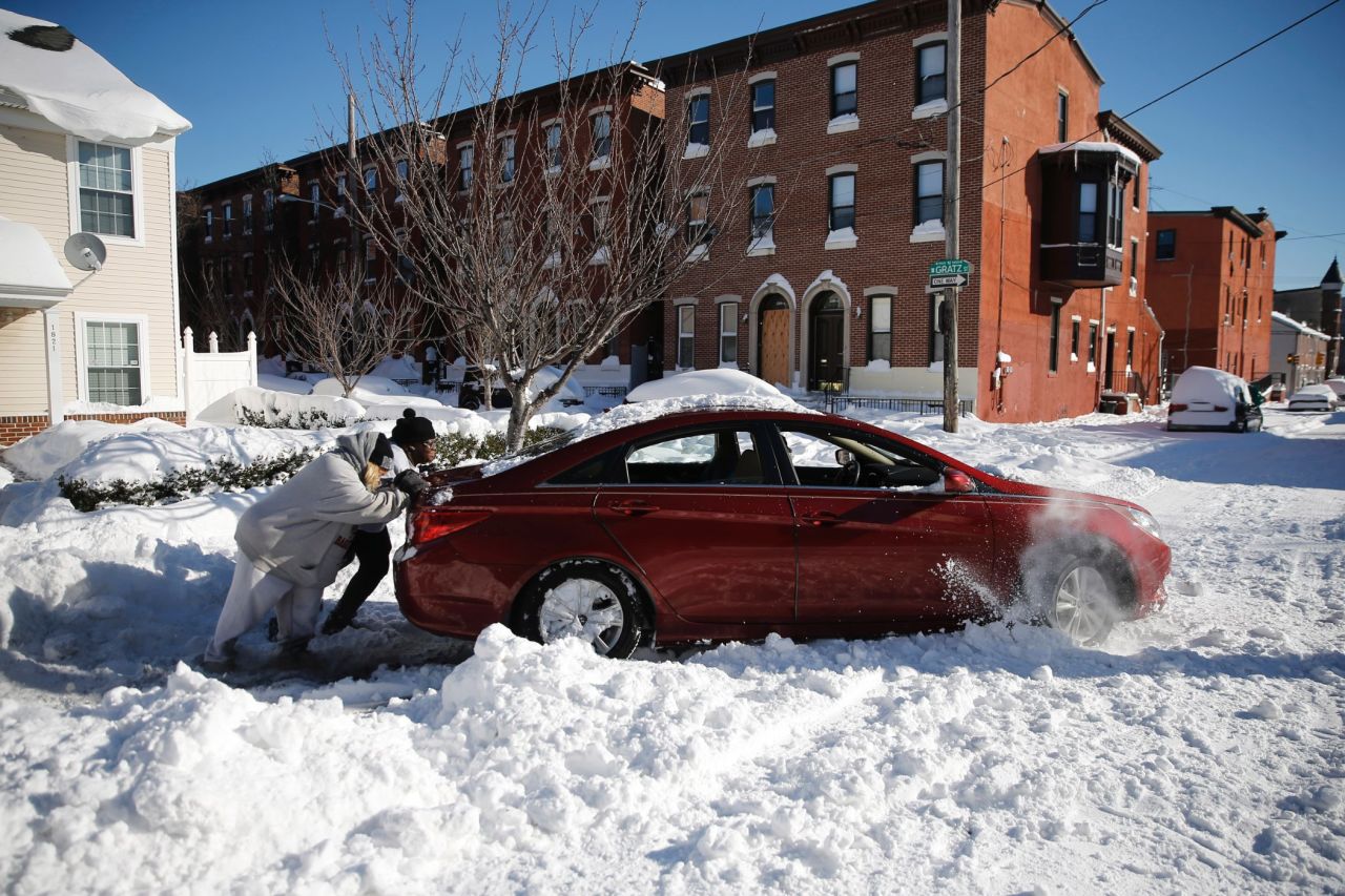 A family tries to push out a snow-bound car in Philadelphia on January 24.