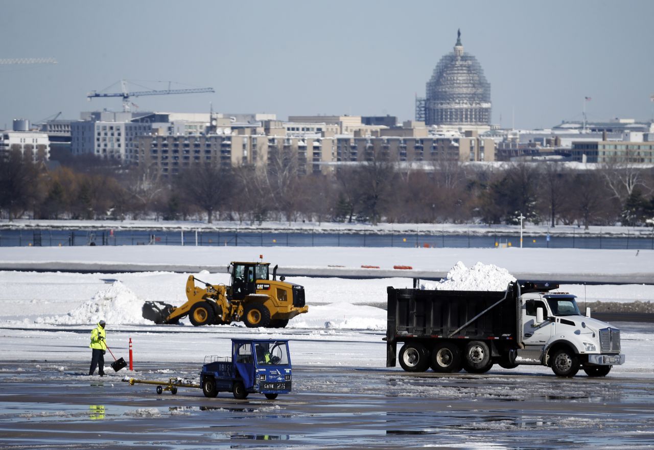 Workers remove snow on the tarmac at  Ronald Reagan National Airport on January 24. 