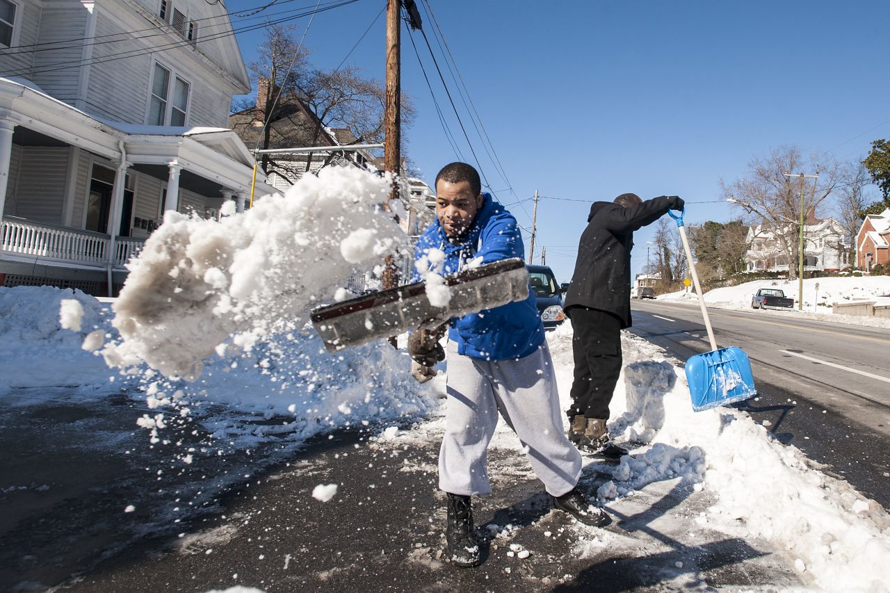 Quan Hill, left, and Lamont Hobson shovel their driveway in Lynchburg on January 24. 