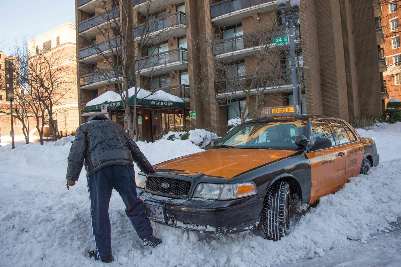 A taxi driver in Washington tries to get his car out of the snow on January 24.