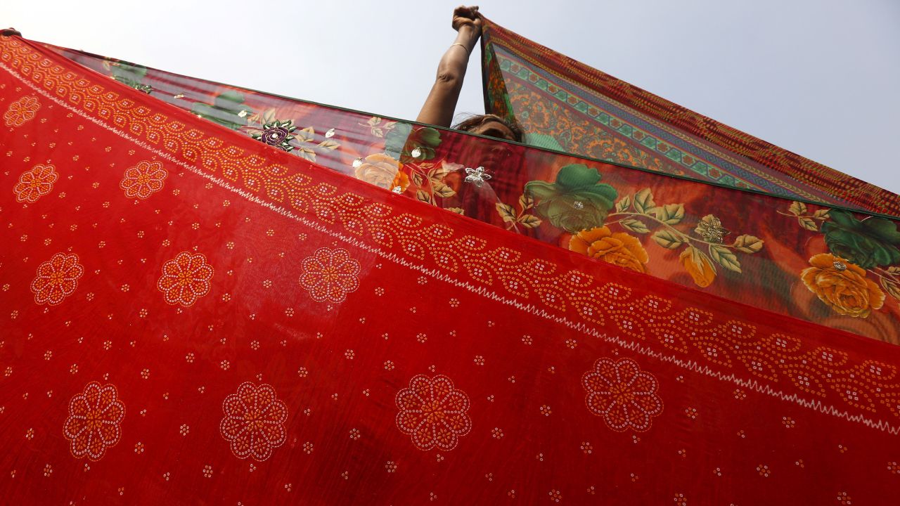 A Hindu pilgrim hangs out saris to dry after taking part in the annual holy dip at Sagar Island on January 14. The event is part of the Makar Sankranti festival, which is celebrated through India, Nepal and Bangladesh. <br />