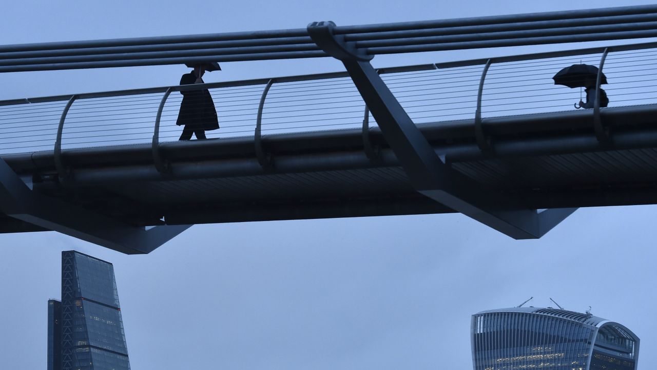 Workers in London cross the Millennium Footbridge, which links St. Paul's Cathedral on the north bank with the Tate Modern art gallery on the south.