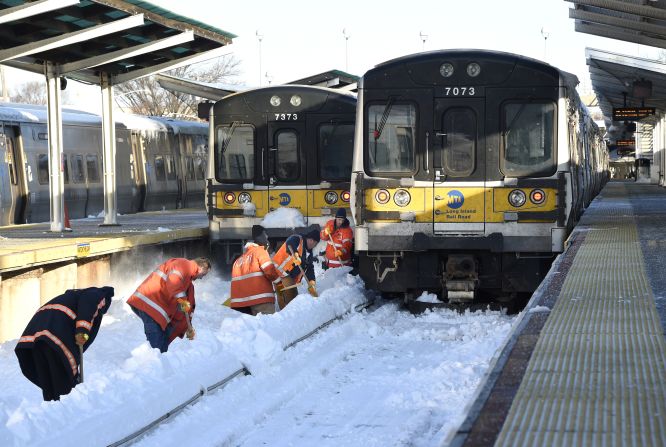 Long Island Railroad workers clear snow off train tracks in Port Washington, New York, on Monday, January 25. A massive winter storm clobbered the East Coast this weekend, shutting down travel in many of the nation's largest cities.