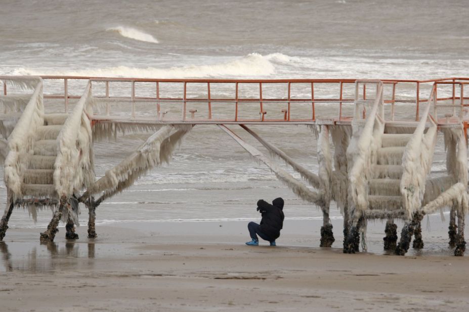 A person photographs icicles on a fence in Shandong, China on Sunday, January 24, 2016.  The state-run Xinhua news agency reported that more than 11,000 air passengers were stranded in Kunming, Yunnan. 