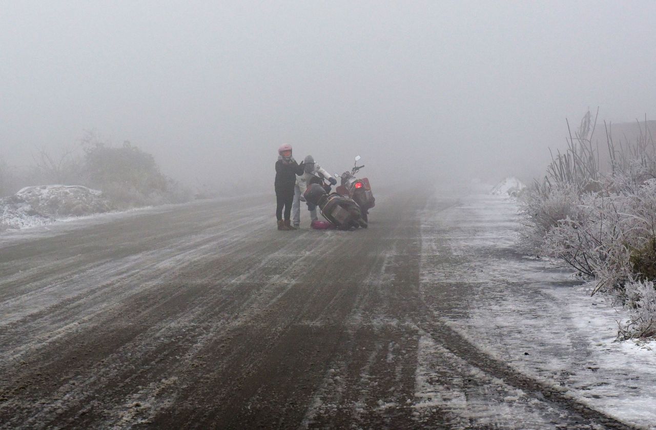 A motorbike rider falls down on an ice-covered highway in Shaoguan, in China's Guangdong province on January 23.