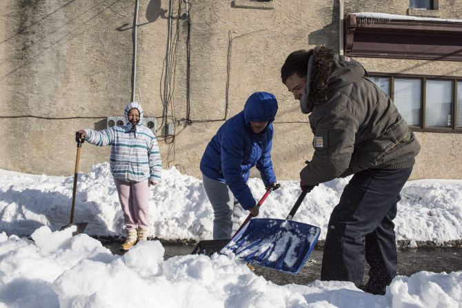 People shovel snow from a covered street in Wilmington, Delaware, on January 25.