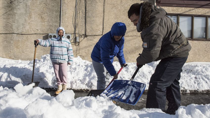 People shovel snow from a covered street in Wilmington, Delaware, on January 25.