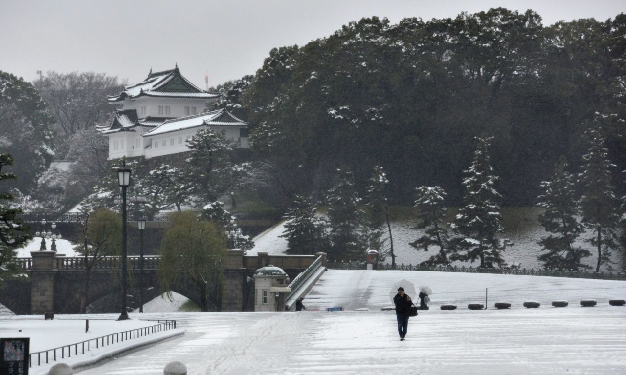 A man walks on a snow covered field in front of the Imperial Palace in Tokyo on January 18. The Amami Oshima island, located in the country's southern Kagoshima prefecture, saw snow for the first time in 115 years.