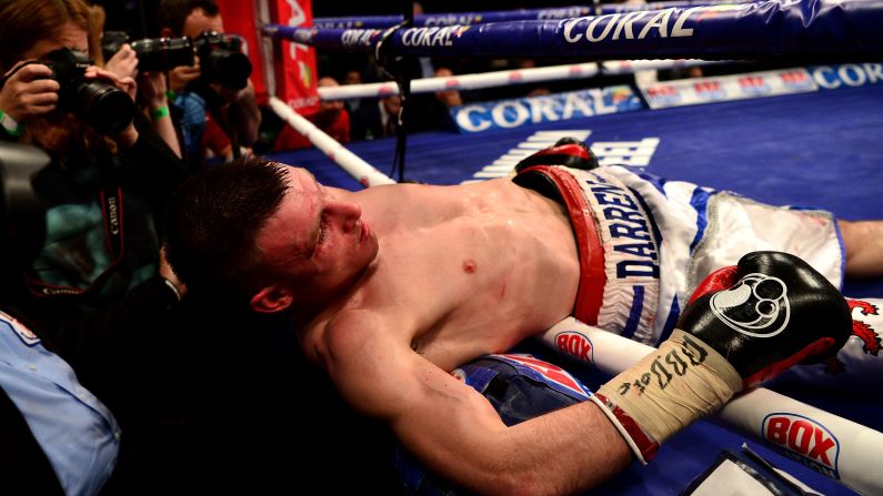 Ringside journalists photograph Darren Traynor after he was knocked through the ropes by Ryan Walsh during a featherweight bout in London on Friday, January 22. Walsh stopped Traynor in the fifth round.