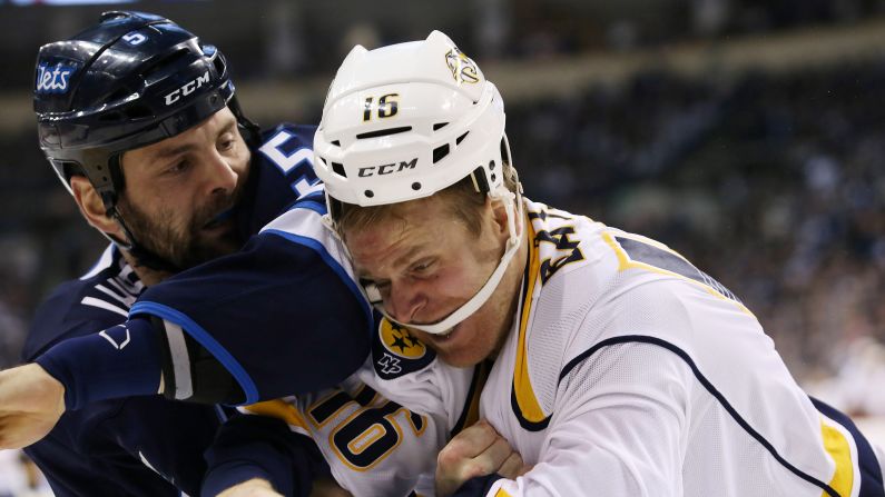 Winnipeg's Mark Stuart, left, fights Nashville's Cody Bass during an NHL game in Winnipeg, Manitoba, on Thursday, January 21.