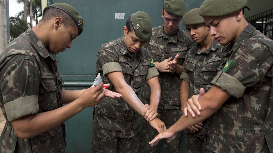 Brazilian soldiers apply insect repellent as they prepare for a cleanup operation in Sao Paulo on Wednesday, January 20.