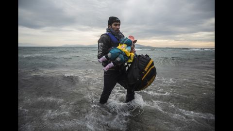 A man carries a child to the shore on January 3.