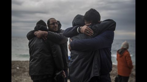 Men hug each other on the beach shortly after crossing the Aegean Sea on Sunday, January 10.