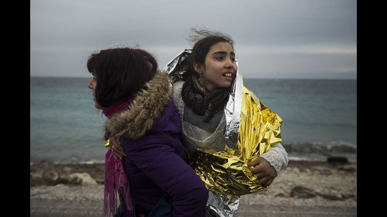 A volunteer walks along the seaside holding a child on January 3.