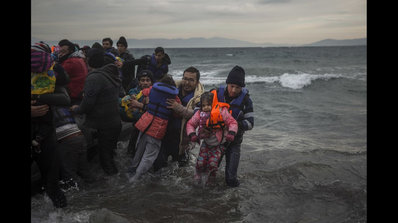 Refugees are helped as they reach the shore on January 3.