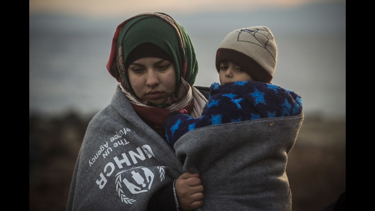 A woman holds a child on the beach after arriving in Lesbos on January 3.
