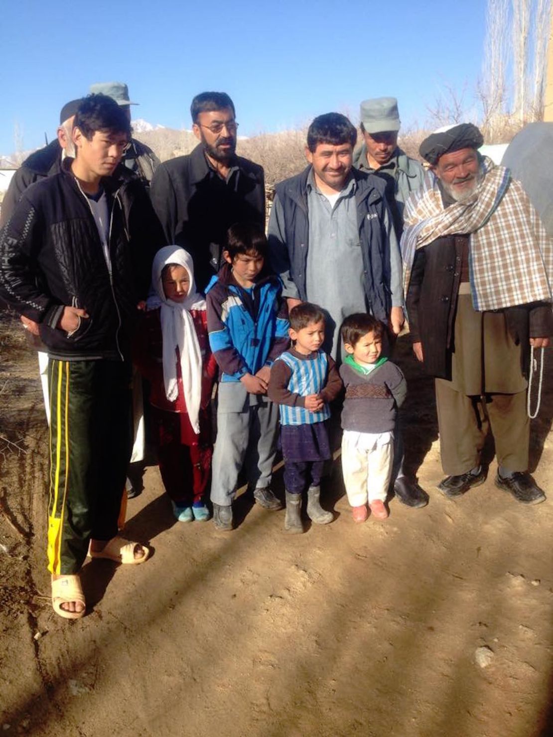 Murtaza poses with local villagers, including his proud father Arif, in the blue vest, third from right.