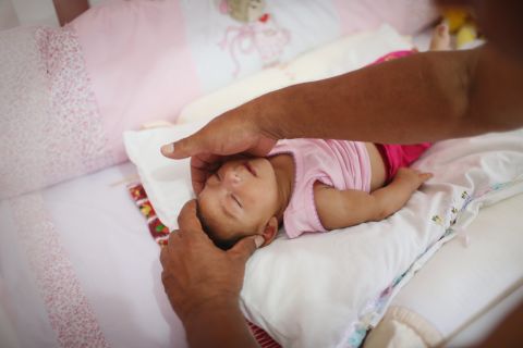 Alice Vitoria Gomes Bezerra, a 3-month-old baby with microcephaly, is placed in her crib by her father Wednesday, January 27, in Recife.