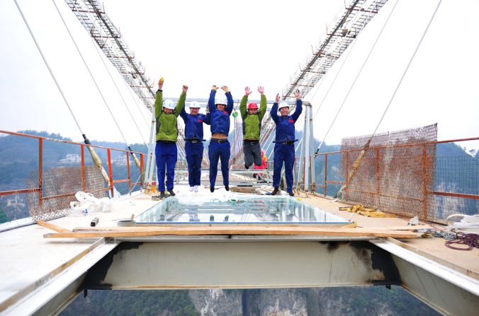 Workers installing the bridge's glass demonstrate just how confident they are in their work by leaping into the air for a picture on January 27.