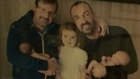 Dario De Gregorio and Andrea Rubera smile with their three children.