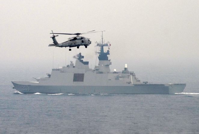 A U.S.-made S-70C helicopter files over a French-made La Fayette-class frigate during a drill off the naval port in Kaohsiung on January 27.