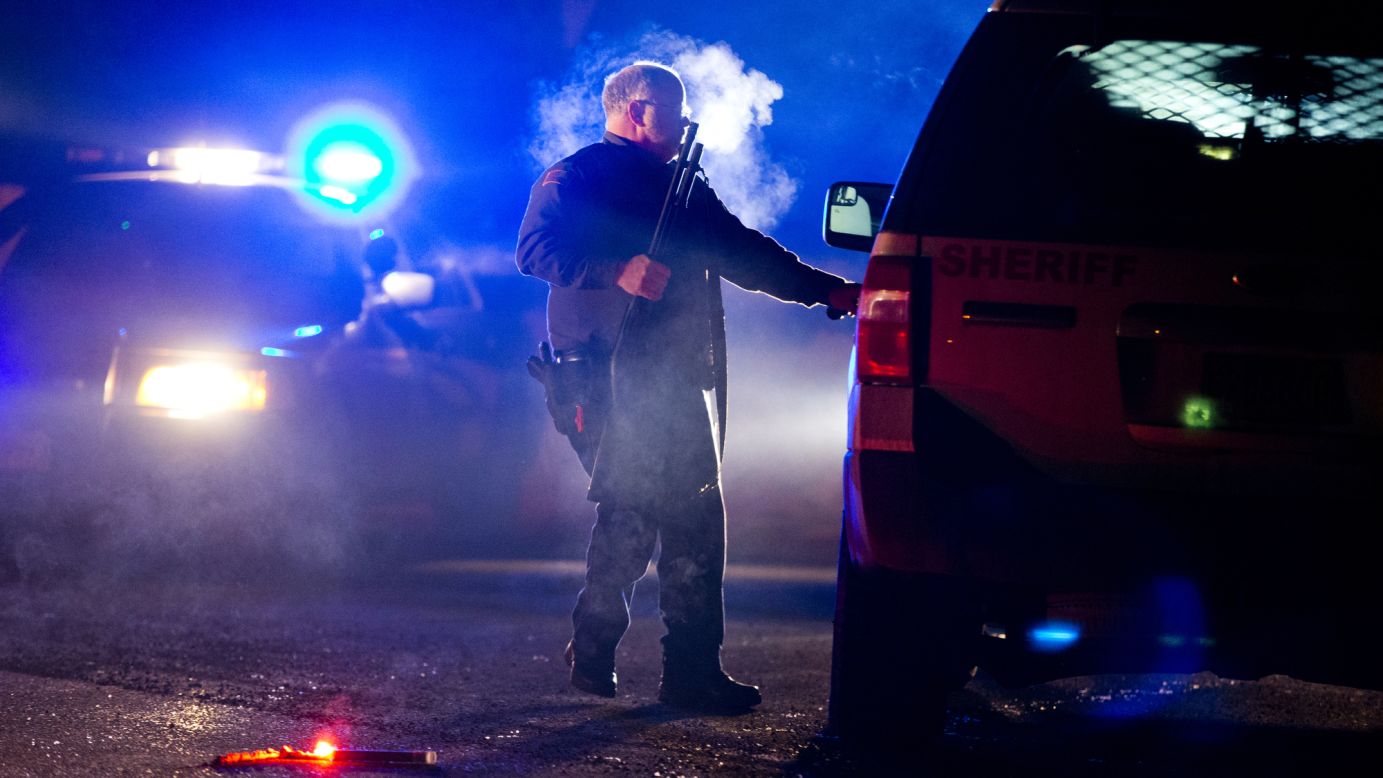 An Oregon state police officer stands by a vehicle as police officers block Highway 395 in Seneca, Oregon, on Tuesday, January 26. The road was blocked to <a href="http://www.cnn.com/2016/01/27/us/oregon-siege-traffic-stop/" target="_blank">arrest leaders of an armed group</a> that has been occupying a national wildlife refuge since January 2. 