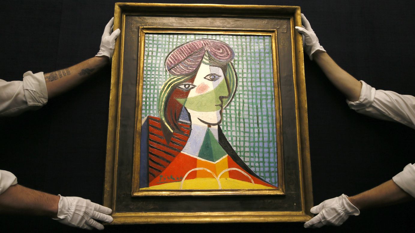 Sotheby's employees adjust the Pablo Picasso painting "Tete de Femme" at an auction room in London on Thursday, January 28. The painting is estimated to be worth $23 million-$29 million. It goes up for auction on February 3.