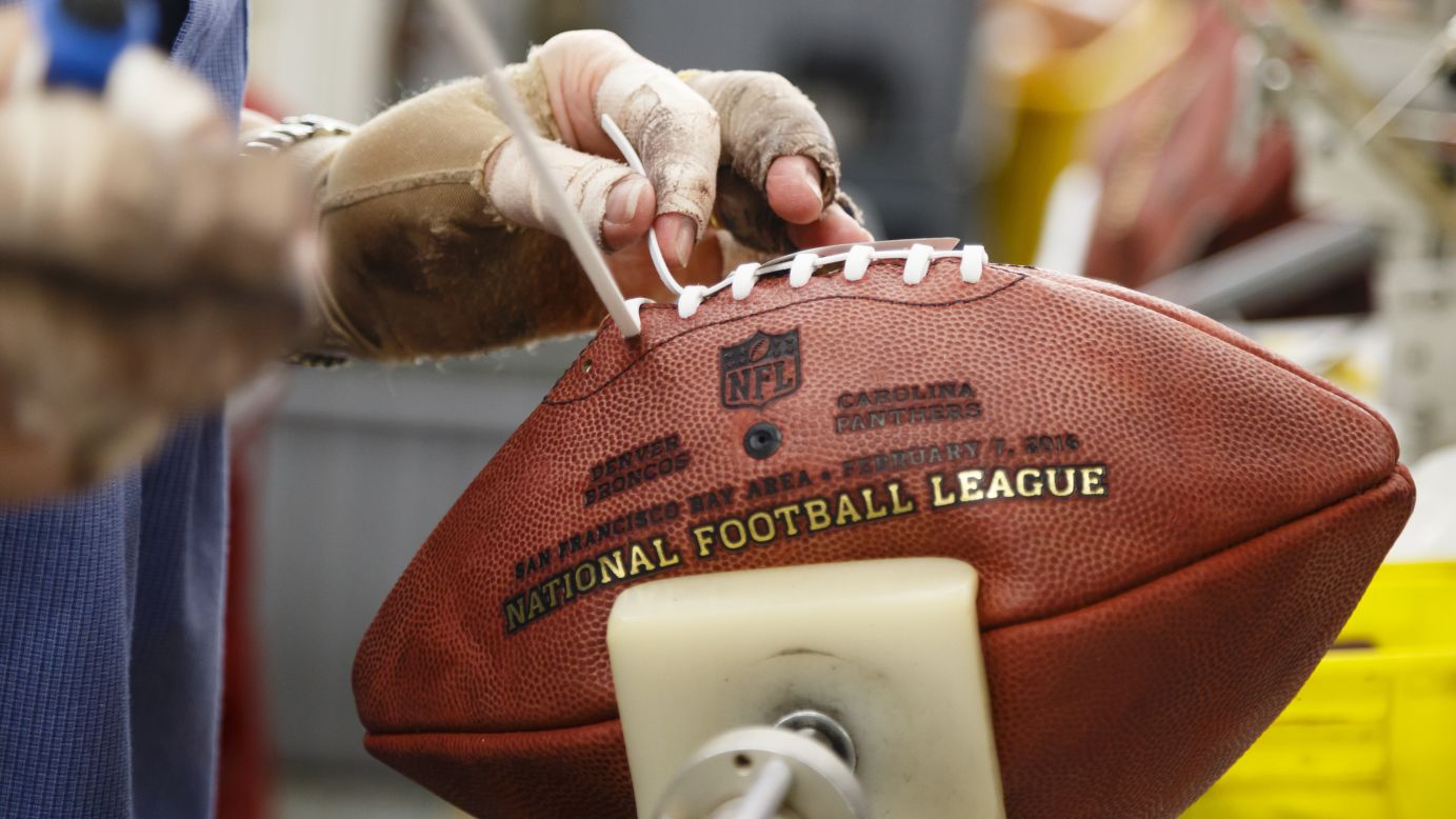 An employee of Wilson Sporting Goods laces a Super Bowl football Tuesday, January 26, in Ada, Ohio. Super Bowl 50 will be played on February 7.