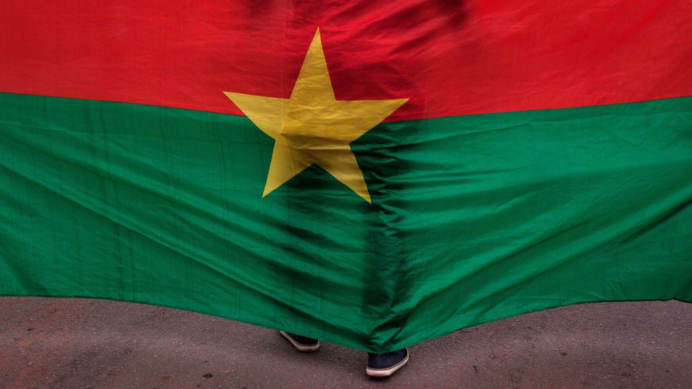 A man in Ouagaougou, Burkina Faso, stands in front of the country's flag during a memorial ceremony held Saturday, January 23, for victims of <a href="http://www.cnn.com/2016/01/16/africa/burkina-faso-hotel-terrorist-attack/" target="_blank">a recent hotel attack.</a> An al Qaeda-linked terrorist group claimed responsibility for the assault at Splendid Hotel.