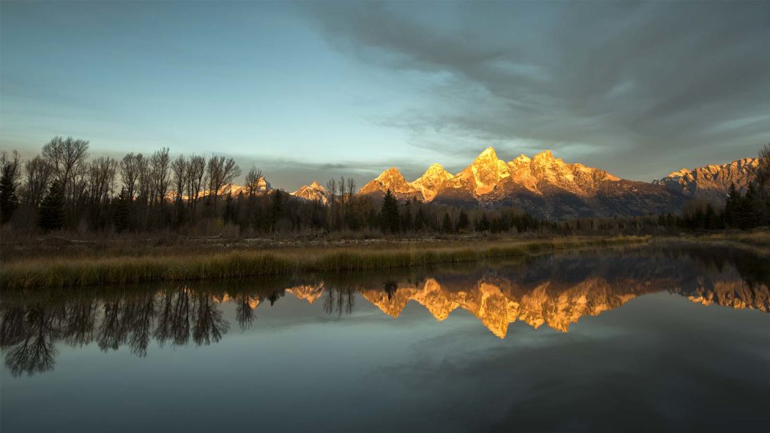 The sunrise reflects on Jackson Lake in Grand Teton National Park.