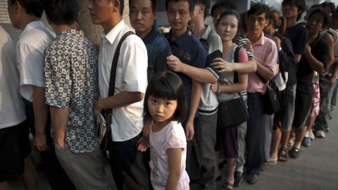 This picture taken in August 2011 shows a girl standing beside her father as hundreds of Chinese parents queue up to see a doctor outside a children's hospital in Beijing. 