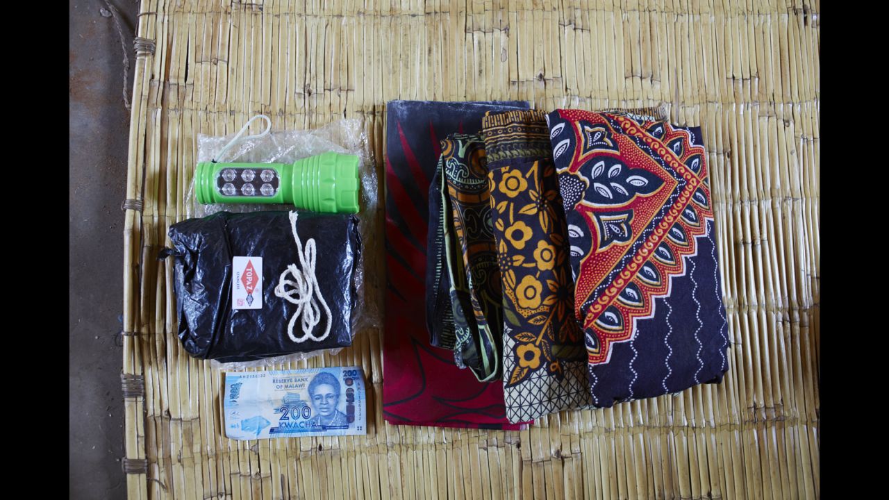 Ellen Phiri's bag includes: a flashlight because there is no electricity, a black plastic sheet to cover the delivery bed because it is it hard to clean the area, a razor blade to cut the umbilical cord, string to tie the umbilical cord, 200 Malawian Kwacha for food, three large sarongs for the mother to wear and to wrap her baby in.