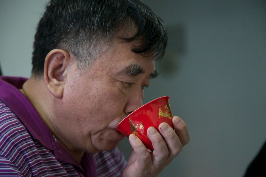 Li drinks tea in his small apartment where he and his wife live on a small monthly pension of around USD$1,200. Since retiring from a state-owned factory, Li works on freelance commissions from his home workshop