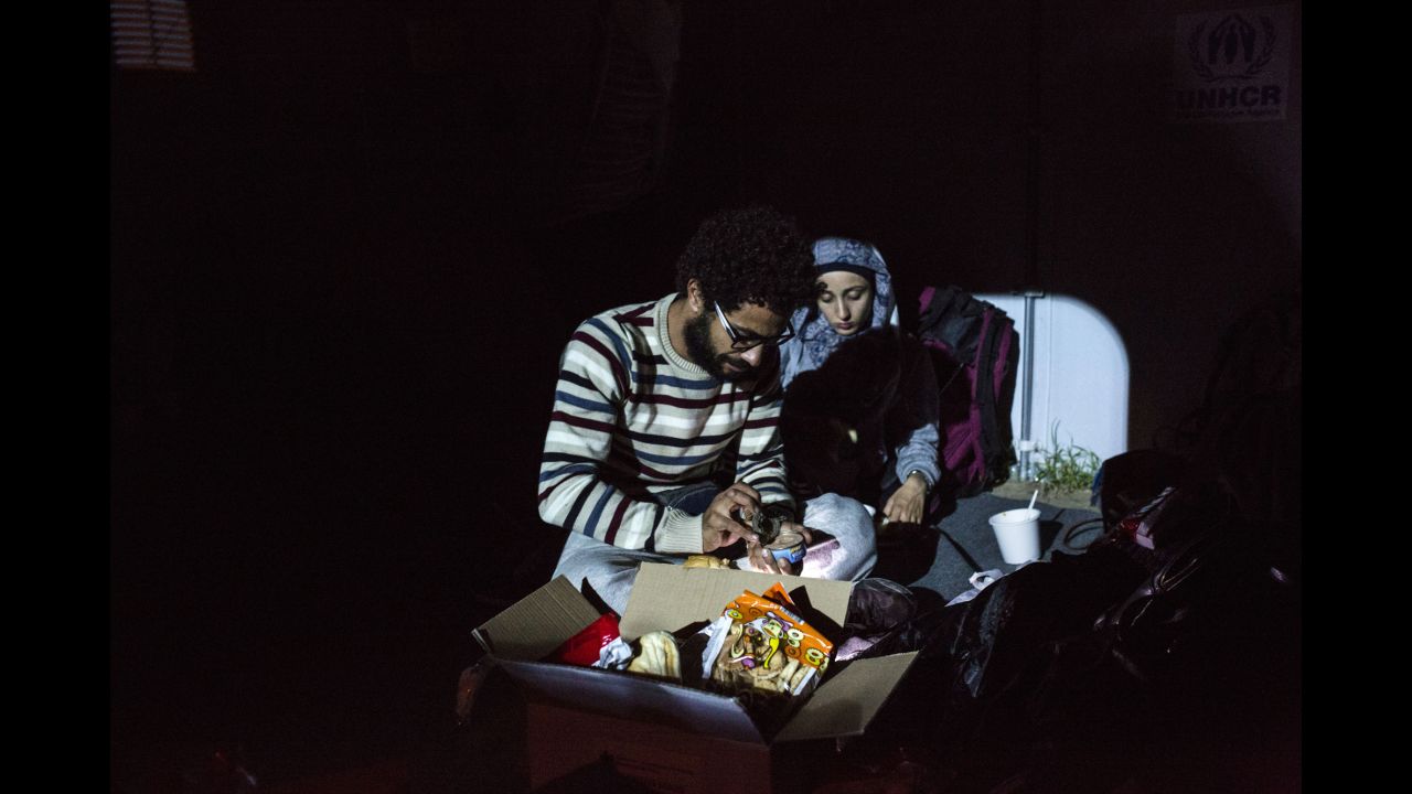 Somar and his sister Salsabil open a box of canned food inside a U.N. camp.