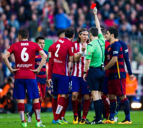 Referee Alberto Undiano Mallenco shows a red card to Filipe Luis after fouling Lionel Messi.