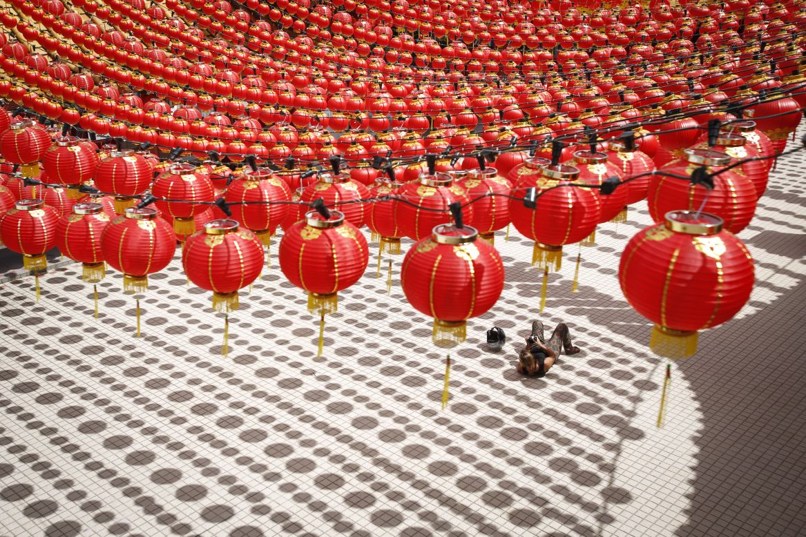 A tourist in Kuala Lumpur lies on a floor cast with shadows of traditional Chinese lanterns on Wednesday, January 27. 