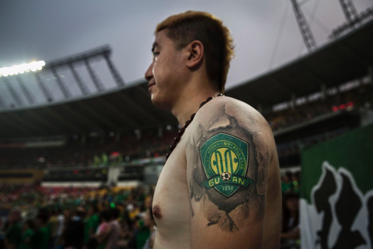 An Ultra supporter of Beijing Guoan shows a tattoo of the team's badge during a match against Chongcing Lifan.