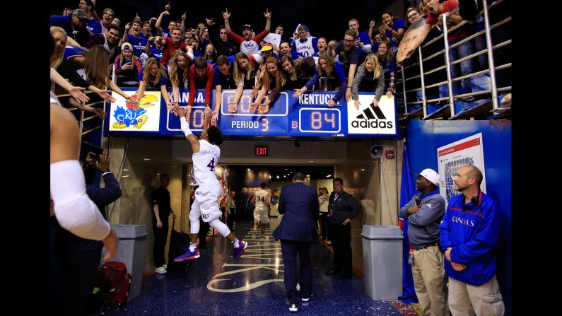 Devonte' Graham high-fives Kansas fans after the Jayhawks defeated Kentucky in Lawrence, Kansas, on Saturday, January 30. Kansas won 90-84 in overtime.