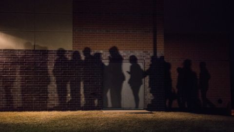 The shadows of lined-up caucusgoers are seen outside a school in West Des Moines. 