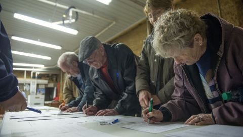 People sign in as they arrive at a Democratic Party caucus in Keokuk, Iowa.