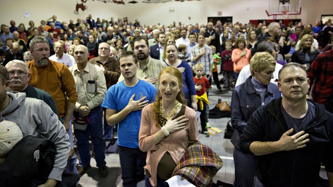 Republican voters sing the national anthem in the gymnasium of an elementary school in Adel, Iowa. 