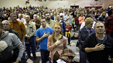 Republican voters sing the national anthem in the gymnasium of an elementary school in Adel, Iowa. 