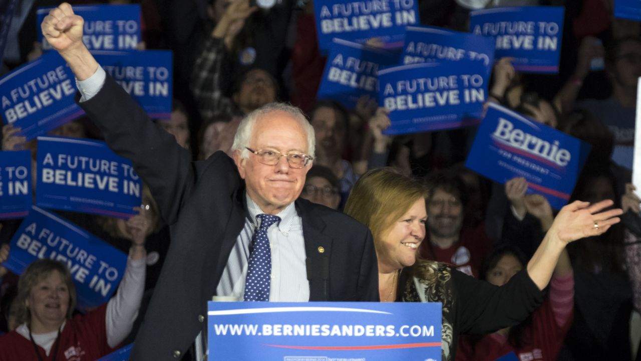 Sanders and his wife, Jane, acknowledge the crowd as he arrives for his caucus night rally in Des Moines. "Nine months ago, we came to this beautiful state, we had no political organization, we had no money, we had no name recognition and we were taking on the most powerful political organization in the United States of America," Sanders said. "And tonight, while the results are still not known, it looks like we are in a virtual tie."