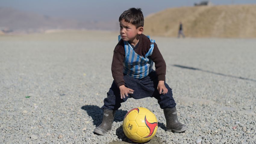 TOPSHOT - Afghan boy five-year-old Murtaza Ahmadi, a young Lionel Messi fan, plays football in Kabul on February 1, 2016. Barcelona star Lionel Messi is hoping to arrange a meeting with an Afghan boy who shot to fame after pictures of him dressed in a striped plastic bag jersey went viral, Kabul's football federation said on February 1. AFP PHOTO / SHAH Marai / AFP / SHAH MARAI        (Photo credit should read SHAH MARAI/AFP/Getty Images)