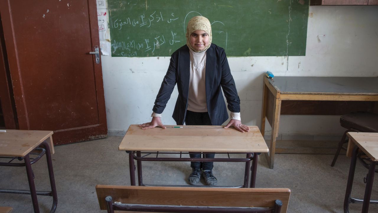 "In this image, it is the early morning, and I am waiting in my classroom for my students to arrive. I teach younger children to read and write Arabic. I am strict, but I go out of my way to gently help those students who are having difficulties."
