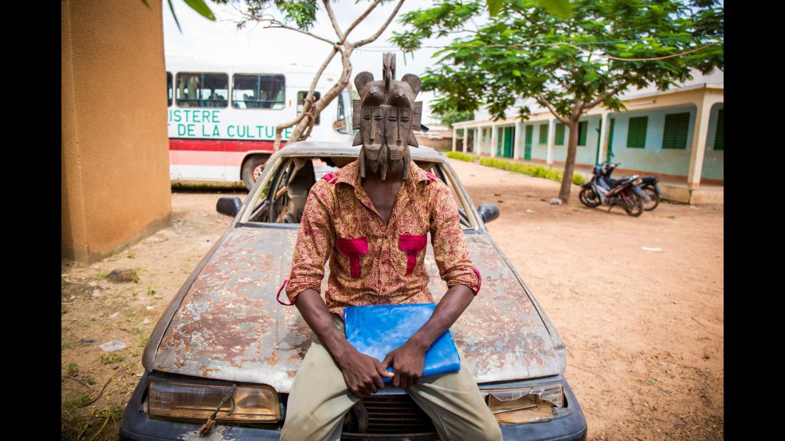 Jakou, 24, is a cartoonist and yoga teacher who moved to Burkina Faso after fleeing the Ivorian conflict in 2010. He is wearing a mask of peace from the Senufo people.