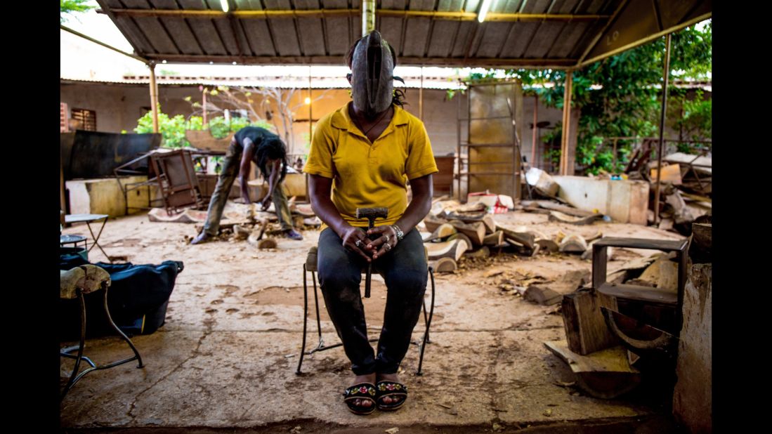 Susanne, 23, wears a mask from the Dogon people. She is training to be a sculptor in Ouagadougou.