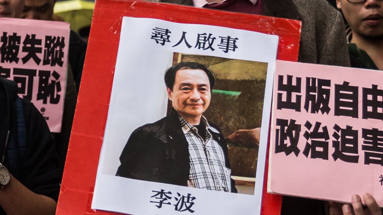 In this picture taken on January 3, 2016, a protestor holds up a missing person notice for Lee Bo, 65, the latest of five Hong Kong booksellers from the same Mighty Current publishing house to go missing, as they walk towards China's Liaison Office in Hong Kong. Britain confirmed on January 5 that one of five missing Hong Kong booksellers feared detained by Chinese authorities is a UK citizen, saying it was "deeply concerned" over the disappearances. AFP PHOTO / ANTHONY WALLACE / AFP / ANTHONY WALLACE        (Photo credit should read ANTHONY WALLACE/AFP/Getty Images)